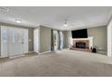 Spacious living room featuring a brick fireplace, neutral carpet, and a ceiling fan at 1930 Huntcliff Dr, Lawrenceville, GA 30043