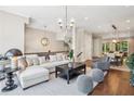 Bright, open-concept living room with hardwood floors, modern lighting, and a view to the dining area at 2172 Peach Se Ln, Smyrna, GA 30080