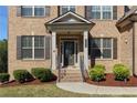 Inviting front porch with brick steps, decorative columns, and meticulously maintained landscaping at 3204 Ivy Farm Path, Buford, GA 30519