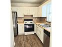 Bright kitchen featuring white cabinets, stainless steel appliances, and wood-look flooring at 3800 Travis Trce, Decatur, GA 30032