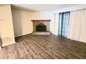 Spacious living room with a brick fireplace and wood-look flooring at 3800 Travis Trce, Decatur, GA 30032