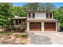 Charming home with two car garage, inviting front porch, well-maintained lawn and mature trees provide curb appeal at 466 Victoria Rd, Woodstock, GA 30189