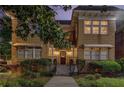 Inviting two-story brick home with manicured landscaping, mature trees, and covered entryway at dusk at 653 N Highland Ne Ave # 3, Atlanta, GA 30306
