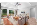 Bright living room with hardwood floors, large windows, tray ceilings, and neutral furniture at 221 The Esplanade Se Way, Loganville, GA 30052