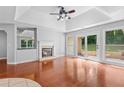 Bright living room with hardwood floors, large windows, fireplace, and tray ceilings at 221 The Esplanade Se Way, Loganville, GA 30052