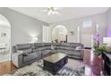 Cozy living room with hardwood floors, arched doorways, ceiling fan and a large sectional sofa at 1010 Capella Creek Way, Grayson, GA 30017