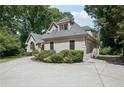View of the home with an attached garage, complemented by mature landscaping and a well-maintained lawn at 1712 Shirley Sw St, Atlanta, GA 30310