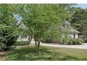 View of the home partially hidden by a large tree in the front yard, with mature landscaping at 1712 Shirley Sw St, Atlanta, GA 30310