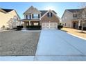 A well-manicured lawn enhances this home's exterior, featuring a two-car garage and brick facade at 2378 Misty Ivy Ct, Buford, GA 30519