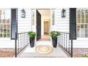 Charming front porch with black accents, a patterned rug, and stylish planters flanking the doorway at 2730 Burtz Dr, Marietta, GA 30068