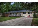 Inviting single-story home with a brick and siding exterior, a cozy front porch, and a spacious driveway, set in a tranquil setting at 8053 Duralee Ln, Douglasville, GA 30134