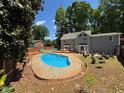 Backyard with in-ground swimming pool surrounded by mature trees at 1153 Staples Sw Dr, Lilburn, GA 30047