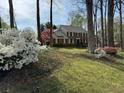 Traditional two-story home surrounded by lush greenery and mature trees at 1153 Staples Sw Dr, Lilburn, GA 30047
