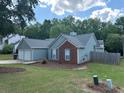 Side view of a charming single Gathering home with light blue siding, brick accents, and a two-car garage at 4811 Lake Park Ter, Acworth, GA 30101