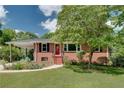 Inviting brick home with covered carport, complemented by well-maintained landscaping and a welcoming red door at 243 Woodview Ln, Smyrna, GA 30082