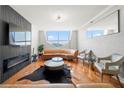 Modern living room featuring a sleek fireplace, wood floors, and city views from large window at 2479 Peachtree Ne Rd # 1801, Atlanta, GA 30305