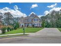 Charming two-story house with brick and stone, lush landscaping, long driveway, and a sunny sky at 859 Heritage Lake Way, Grayson, GA 30017