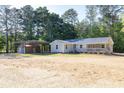 Attractive single-story home with a long porch, carport, and two-car garage, nestled in a wooded setting at 1508 Franklin Cir, Dacula, GA 30019
