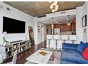 Open-concept living room and kitchen with modern furnishings and concrete ceilings at 855 Peachtree Ne St # 3005, Atlanta, GA 30308
