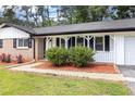 A welcoming front porch featuring stylish black shutters and neatly trimmed landscaping at 1753 Pounds Rd, Stone Mountain, GA 30087