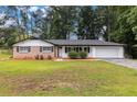 Charming single-story home with brick facade, manicured lawn, and attached two-car garage at 1753 Pounds Rd, Stone Mountain, GA 30087
