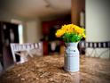 Close-up of a dining table centerpiece with yellow flowers at 220 Baltimore Ave, Stockbridge, GA 30281