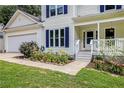 Charming two-story home features a covered front porch and beautifully landscaped front yard at 7155 Bannister Park Ln, Cumming, GA 30028