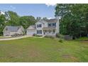 Charming two-story home featuring a well-manicured lawn, an attached garage, and inviting front porch at 7155 Bannister Park Ln, Cumming, GA 30028