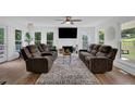 Bright living room with cozy seating, fireplace, ceiling fan, and hardwood floors at 7155 Bannister Park Ln, Cumming, GA 30028