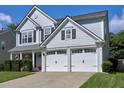 A two-story home with gray siding features an attached two-car garage and a well-manicured lawn at 566 Lullingstone Se Dr, Marietta, GA 30067