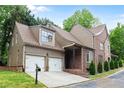 Stunning home with a two-car garage, stylish siding, and brick accents, enhancing its architectural charm and curb appeal at 580 Cliftwood Ct, Sandy Springs, GA 30328