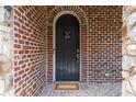 Inviting front door with brick surround and elegant hardware, creating a warm welcome at 580 Cliftwood Ct, Sandy Springs, GA 30328
