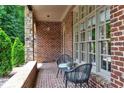 Inviting brick-paved porch with stone accents, complete with chairs and a table for outdoor relaxation at 580 Cliftwood Ct, Sandy Springs, GA 30328