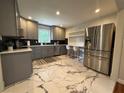 Modern kitchen featuring stainless steel appliances, stylish gray cabinetry, and elegant marble flooring at 910 Oriole Se Ln, Marietta, GA 30067