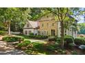 Elegant home with stone and stucco exterior, set amidst lush greenery and a decorative fountain at 1240 Bridgewater Walk, Snellville, GA 30078