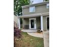 Covered front porch showcasing a decorative door, seating area and landscaping at 2320 Glynmoore Dr, Lawrenceville, GA 30043