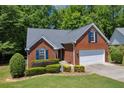 Traditional brick home featuring an attached garage and lush landscaping at 415 Stephanie Ct, Stockbridge, GA 30281