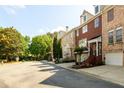Street view of brick townhomes with two-car garages in a tree-lined community at 10090 Jones Bridge Rd # 2, Alpharetta, GA 30022
