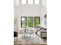 Bright living room with soaring ceilings and expansive windows offering serene views of the surrounding greenery at 187 Clay Se St, Atlanta, GA 30317