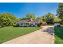 Attractive single-story home with a well-kept lawn, accented by a red flowering shrub and a paved driveway at 2492 Bermuda Dr, Loganville, GA 30052