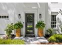 Welcoming front entrance with stylish planters, contemporary lighting, and elegant black framed glass door at 4331 Volnay Ne Ct, Marietta, GA 30066
