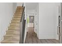 Elegant hallway features a staircase, shiplap walls, and stylish flooring leading to an open-concept kitchen at 4331 Volnay Ne Ct, Marietta, GA 30066