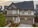 Beautiful two-story home boasts an attached garage, covered porch, landscaped yard, and neutral color scheme at 1010 Fendley St, Woodstock, GA 30188