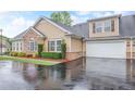 Beautiful exterior featuring a tan siding, brick accents, two-car garage and well-maintained landscaping at 2595 Grapevine Cir, Cumming, GA 30041