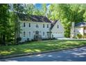 Traditional home with a manicured front lawn, blue entry door, and a two-car garage at 3295 Waters Ml, Alpharetta, GA 30022