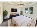 This cozy primary bedroom with a large window and a tray ceiling has been virtually staged at 3479 Woodruff Ridge Ln, Loganville, GA 30052