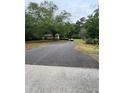 Charming single-story home nestled on a wooded lot with a private driveway and mature shade trees at 4897 Lou Ivy Rd, Peachtree Corners, GA 30096