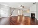 Open living room with hardwood floors, fireplace, staircase, and seamless flow to the dining area at 9165 Nesbit Ferry Rd # 9, Alpharetta, GA 30022