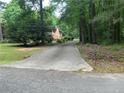 Secluded brick home with a long driveway surrounded by mature trees and lush greenery at 19 Margrit Ct, Stockbridge, GA 30281