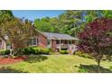 Charming brick home with a covered front porch and lush landscaping at 19 Margrit Ct, Stockbridge, GA 30281